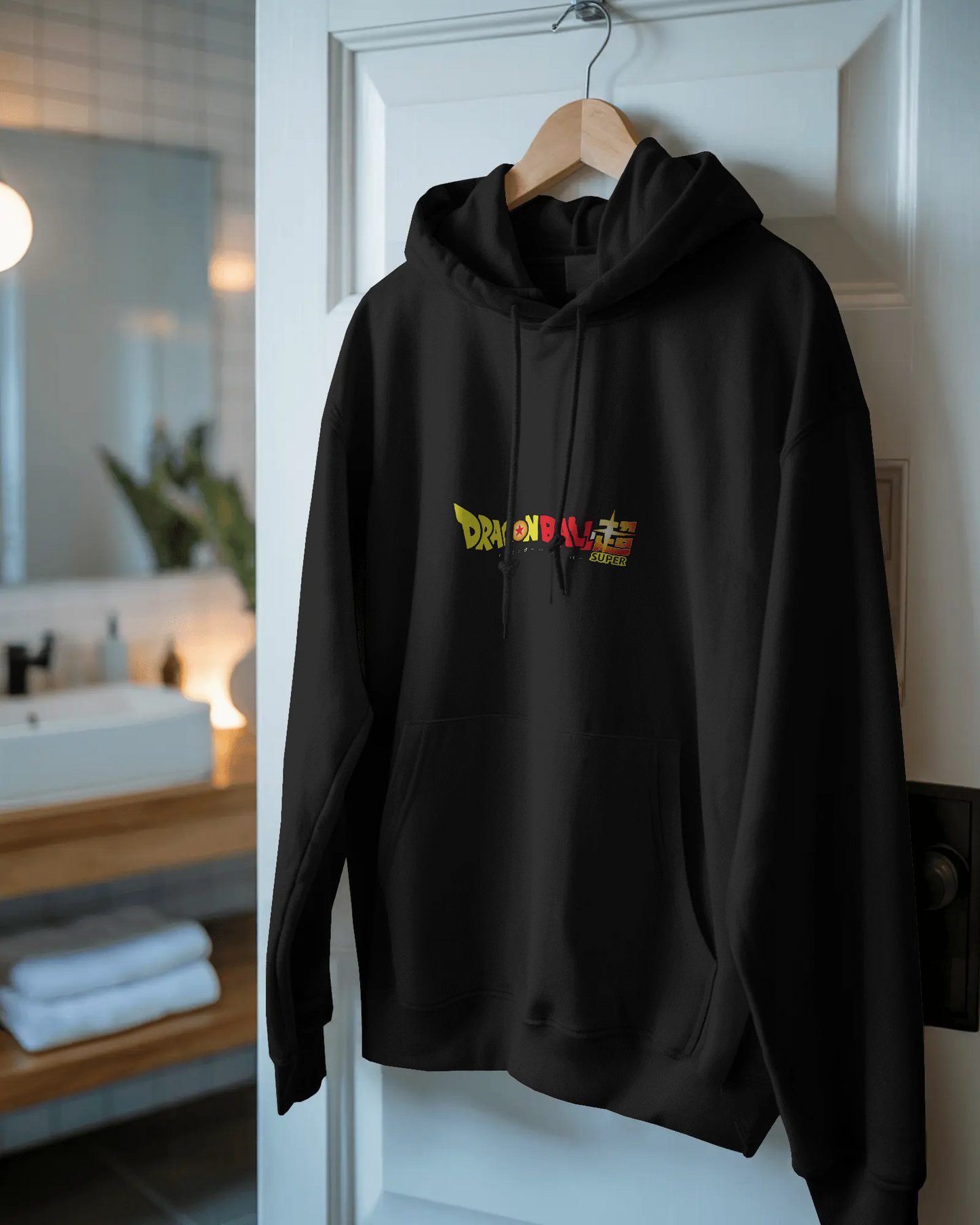 Black hoodie with colorful text design hanging on a door in a room.