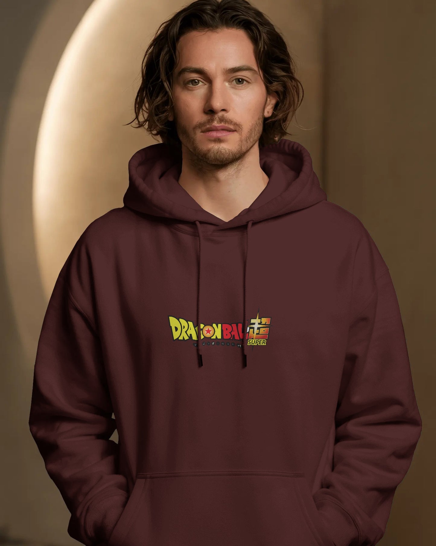 Man wearing a maroon hoodie with a colorful logo on a brown background